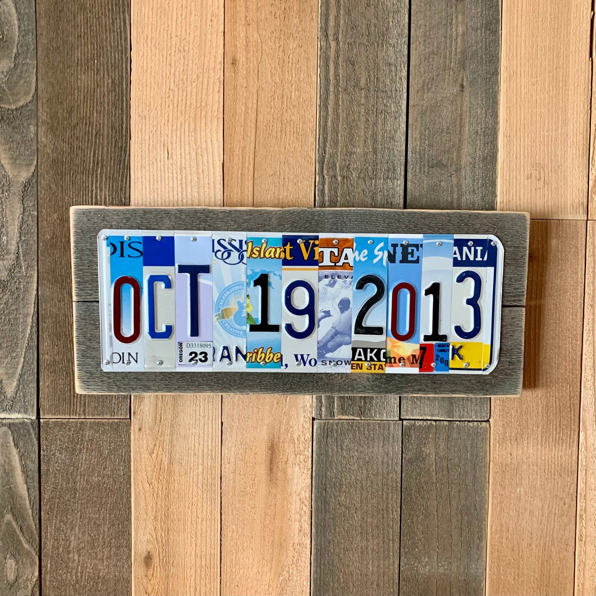traditional 10th anniversary aluminum gift is made using license plates that have been cut into letter and number slices to form a custom wedding date.